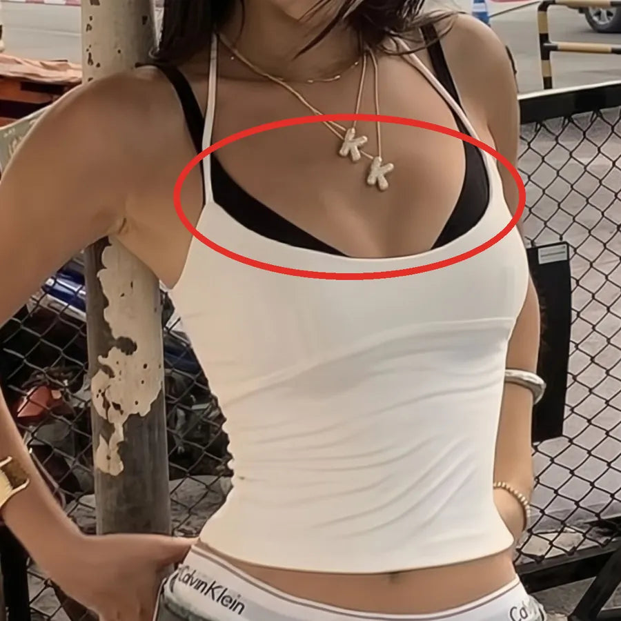 Black bra showing under a white halter cami